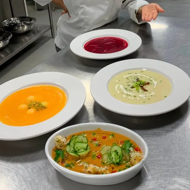 Chef Genesis presenting four plated soups