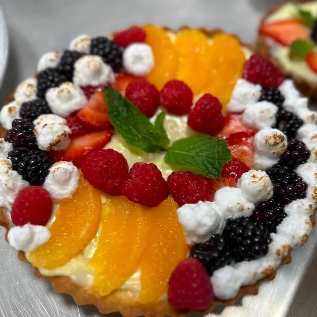 Fruit tart with torched meringue, fresh berries, and mint